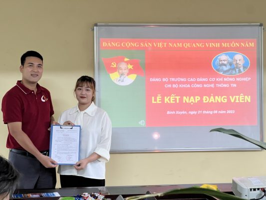 Đồng chí Vũ Bá Tòng - Bí thư chi bộ khoa CNTT trao quyết định kết nạp Đảng cho quần chúng ưu tú Dương Thị Thùy Dung